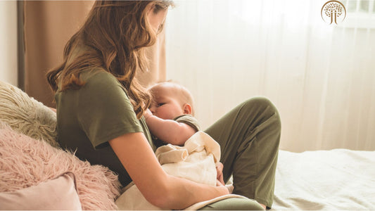 Stillende Mutter mit Baby auf Sofa